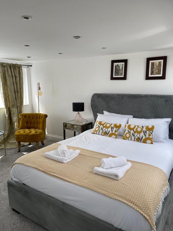 um quarto com uma cama grande com duas toalhas em Cowley Road Stay em Oxford