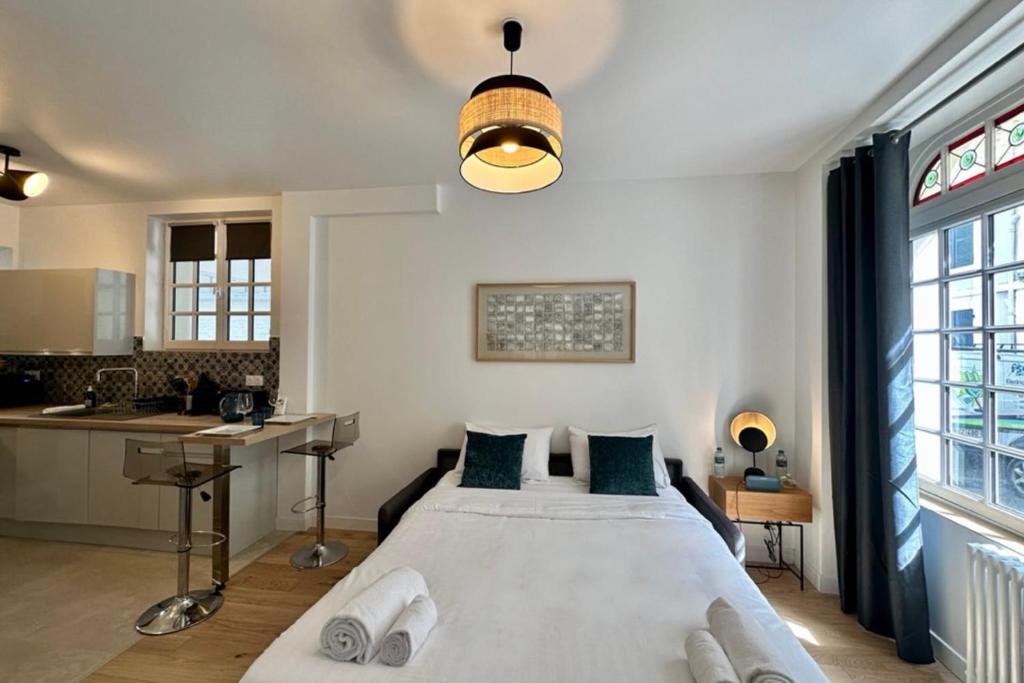 a bedroom with a large bed and a kitchen at Rive Droite - Studio Trouville in Trouville-sur-Mer