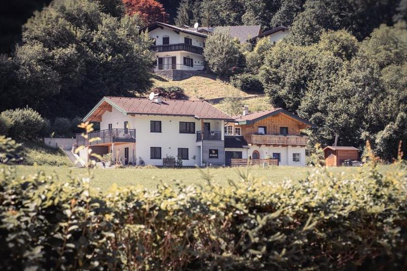 a large white house on a hill in a field at Apartments z‘Haus in Sankt Gilgen