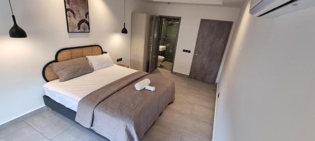 a bedroom with a bed with a white object on it at Amal Suites in Accra