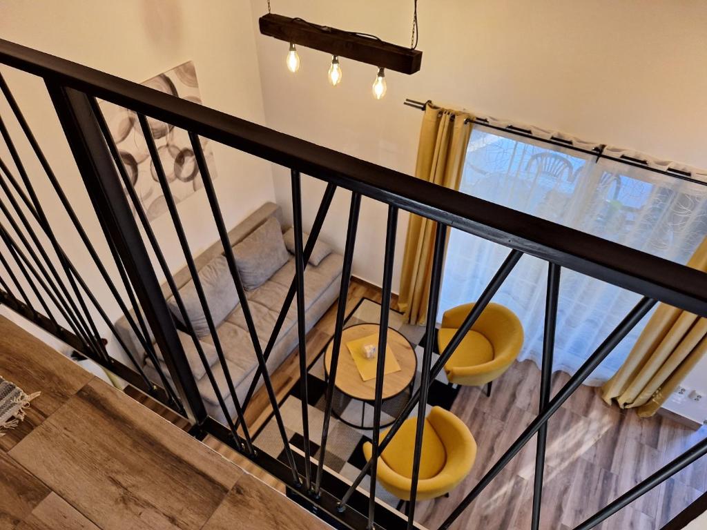 a room with a balcony with two yellow chairs and a table at Kuća za odmor Sweet Home in Vukovar