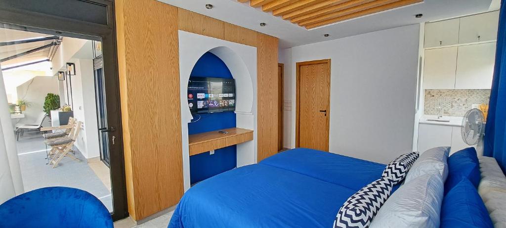 a bedroom with a blue bed and a kitchen at RABAT RESIDENCE in Rabat