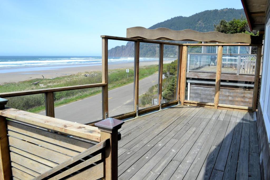 a wooden balcony with a view of the beach at Neahkahnie MCA#50060 in Manzanita