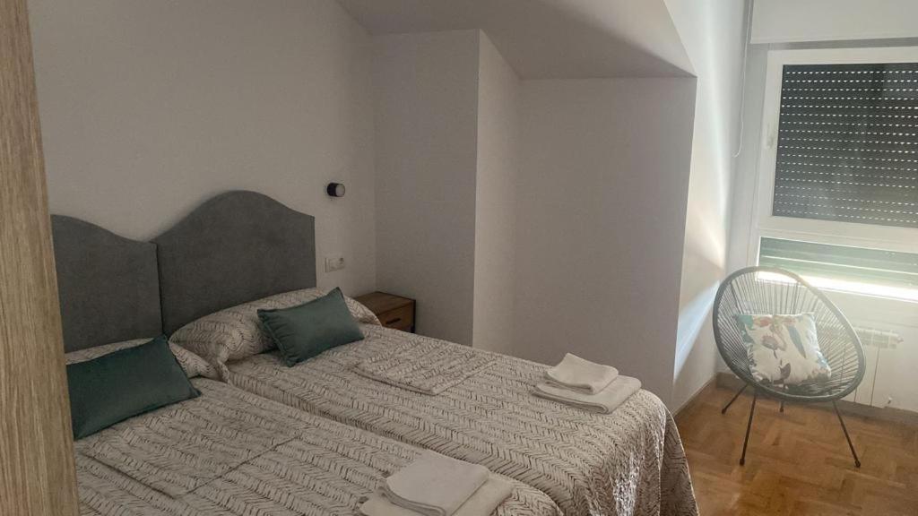 a bedroom with a bed and a fan and a window at Valdellera VI in Posada de Llanes