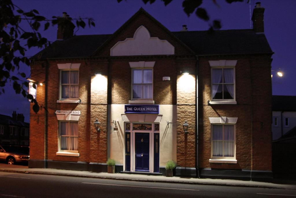 un edificio de ladrillo con luces en la parte delantera en The Queen Hotel, en Olney