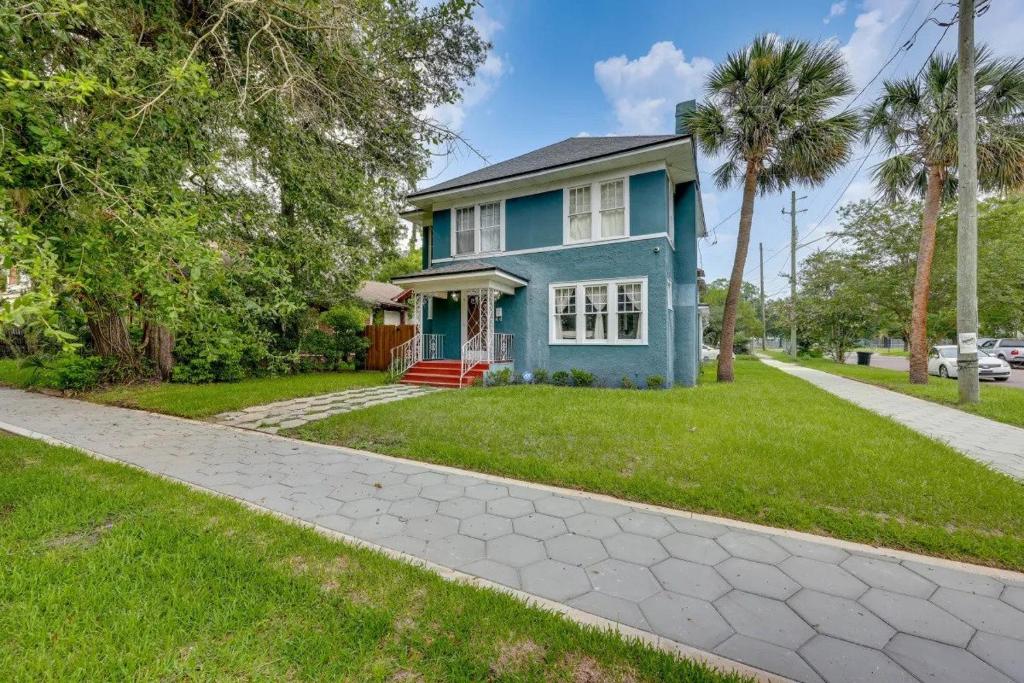 une maison bleue avec des palmiers et un trottoir dans l'établissement Pet friendly home in Historic Springfield near TIAA, à Jacksonville