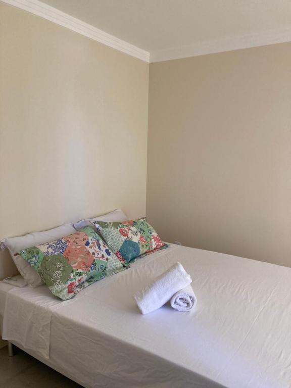 a bed with two towels and a pillow on it at POUSADA RECANTO DULE in Guarapari