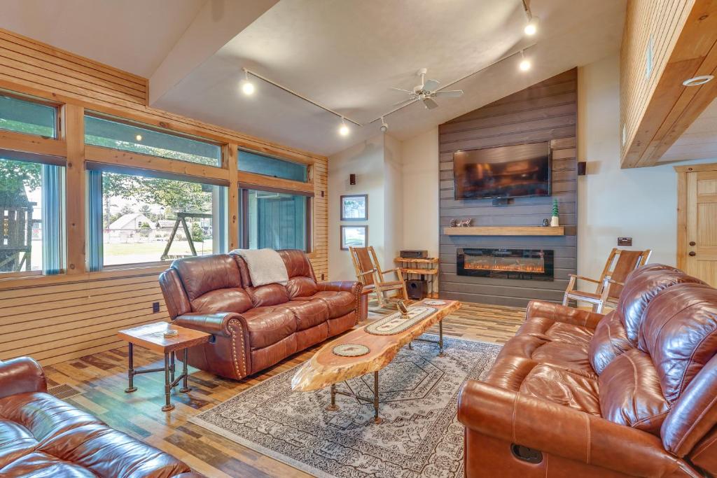 a living room with leather furniture and a fireplace at Spacious Old Forge Condo w/ Patio & Fire Pit! in Old Forge