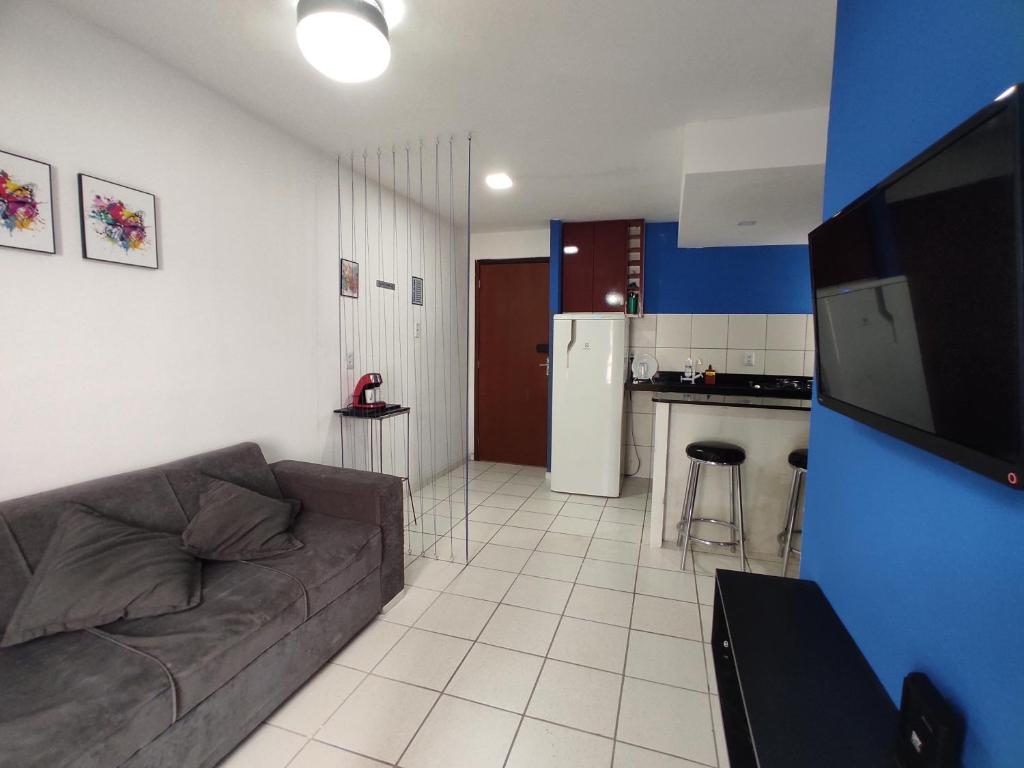ein Wohnzimmer mit einem Sofa und einer Küche in der Unterkunft Flat Smart Home in São Luís