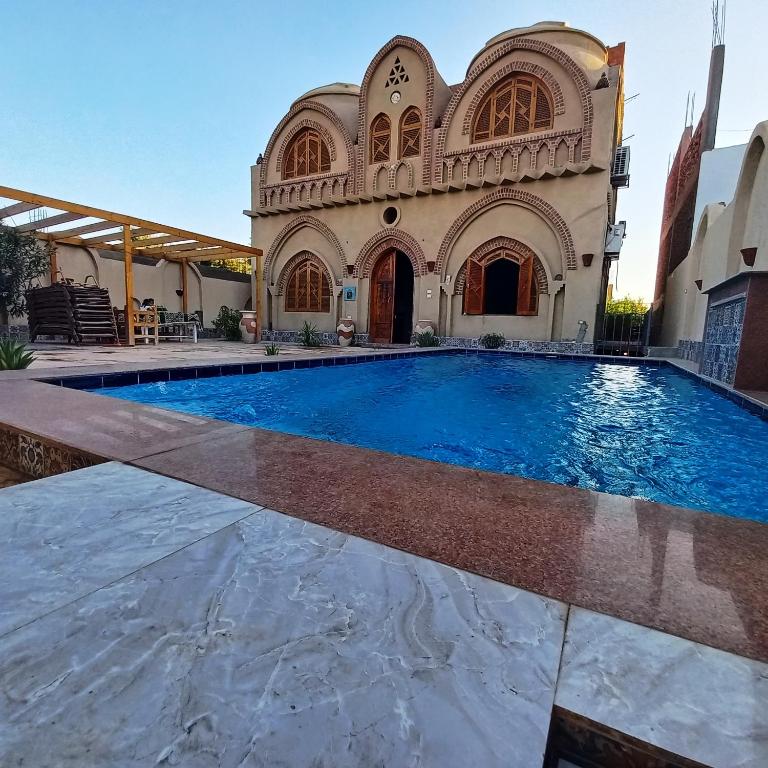 uma grande piscina em frente a um edifício em Mystical habou domes villa em Luxor