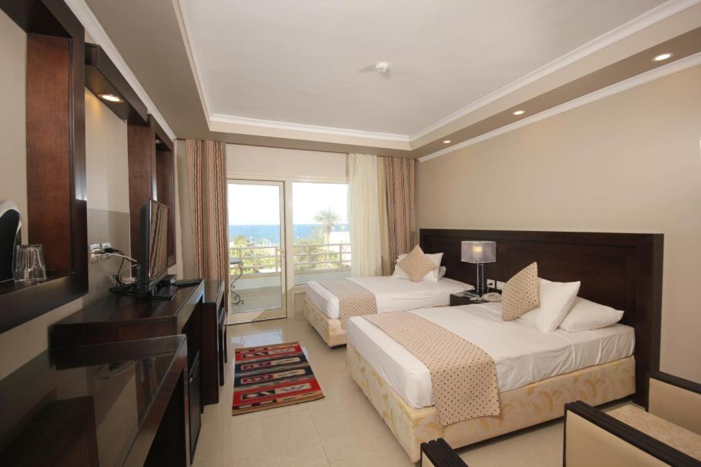 a hotel room with two beds and a balcony at Salvatore Room With Breakfast- Garden View in Alexandria