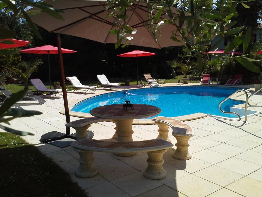 a fountain in front of a pool with chairs and umbrellas at GUTKOWSKI Jacqueline in Saint-Philbert-de-Bouaine