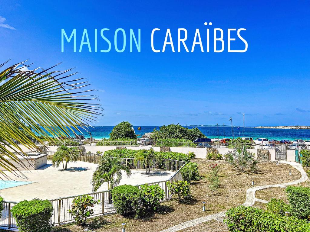 a view of the beach and the ocean with the words mission carlsbad at Maison Caraibes beach front on Orient Bay with 2 big pools in Orient Bay