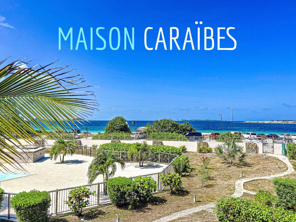 una vista sulla spiaggia e sull'oceano con le parole missione Carl's di Maison Caraibes beach front on Orient Bay with 2 big pools a Orient Bay