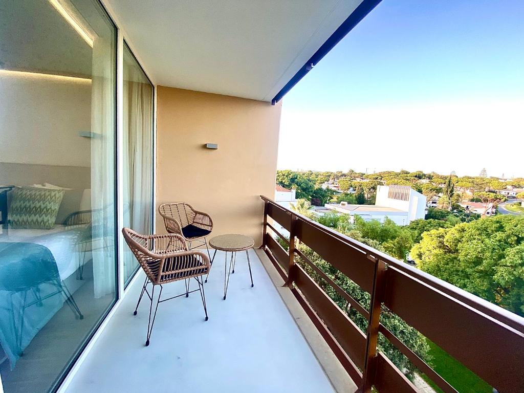 a balcony with two chairs and a table and a bed at Marina Walk Apartment in Vilamoura
