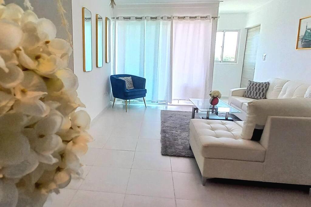 salon z białą kanapą i niebieskim krzesłem w obiekcie 7F apartamento 3hab piscina ascensor y area social w mieście Santiago de los Caballeros