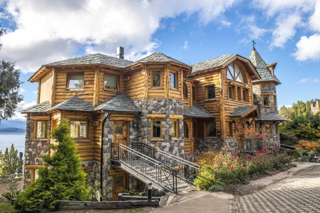 a large wooden house with a stone facade at Lirolay apartments in San Carlos de Bariloche