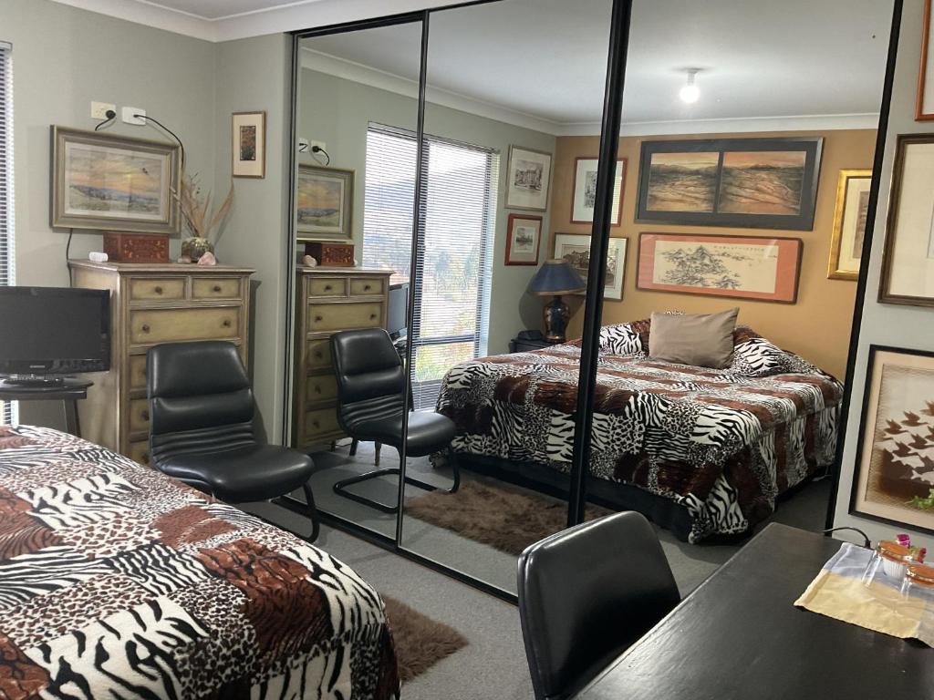 a bedroom with two beds and a mirror at Art House in Huonville
