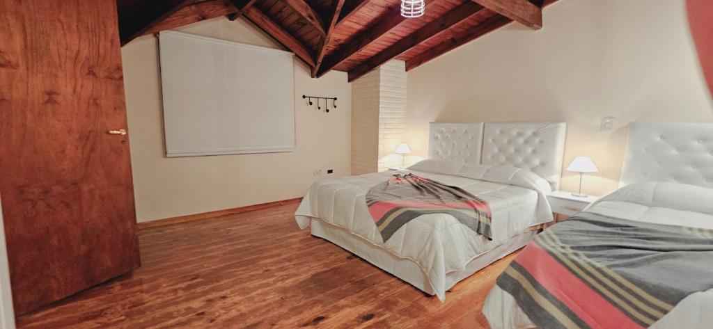 a bedroom with two beds and a large window at La Alpina dpto in El Calafate