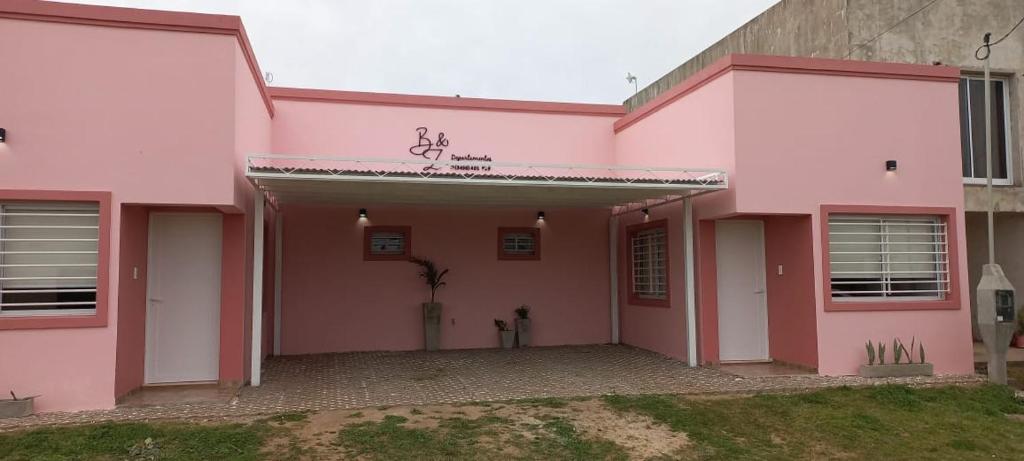 ein rosafarbenes Haus mit Garage in der Unterkunft B&Z Departamentos in Federación