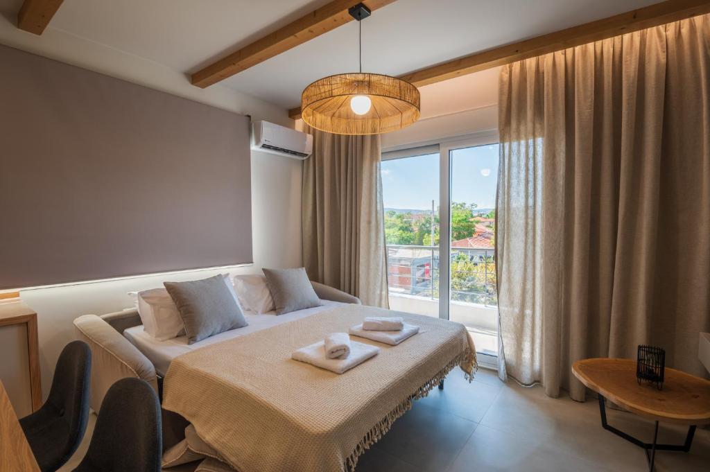 Habitación de hotel con cama y ventana grande en Palaia Luxury Suite, en Volos