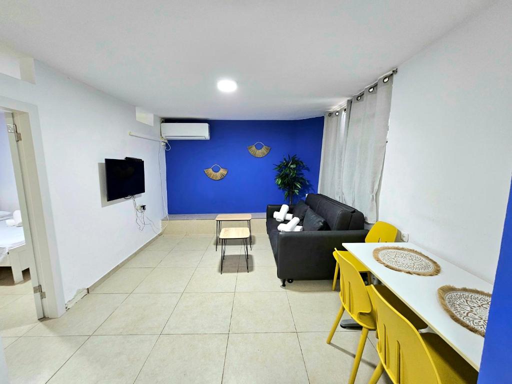 un soggiorno con divano e parete blu di סוויטת מרלו - Merlot Suite a Eilat