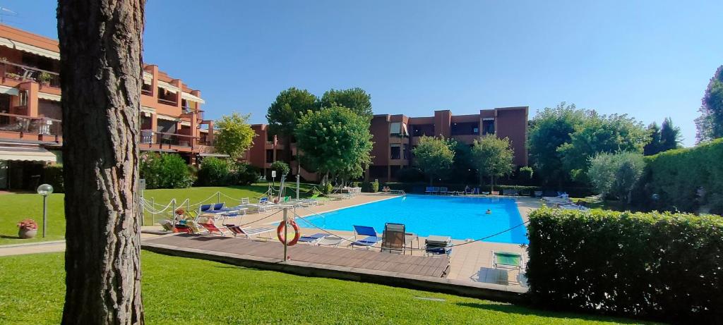 a large swimming pool with chairs and a building at bilocale in residence CIR 017067-LNI-00151 in Desenzano del Garda