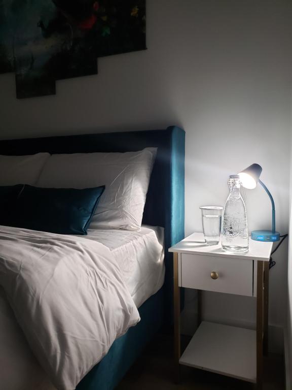 una cama con una lámpara en una mesita de noche junto a una cama en Peace down the corner, en Mission