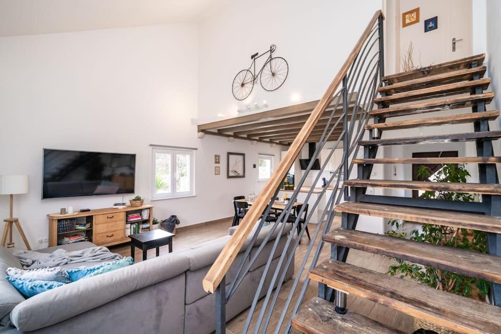 a living room with a staircase and a couch at NIMA Cozy Stay Mlini in Mlini