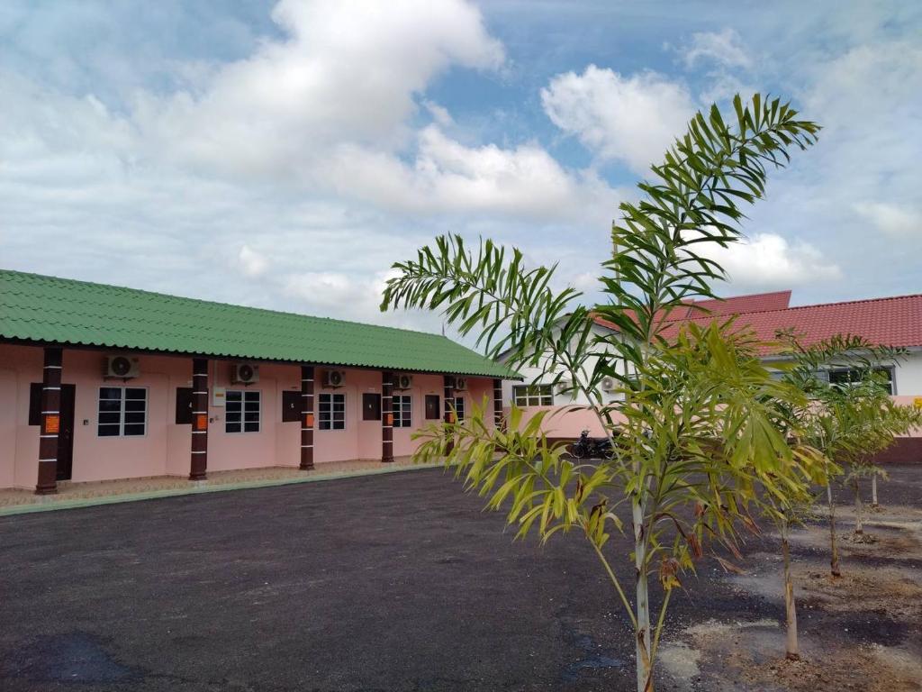 ein Gebäude mit einer Palme davor in der Unterkunft Chalet Sri Bayu in Kampong Balai Maras