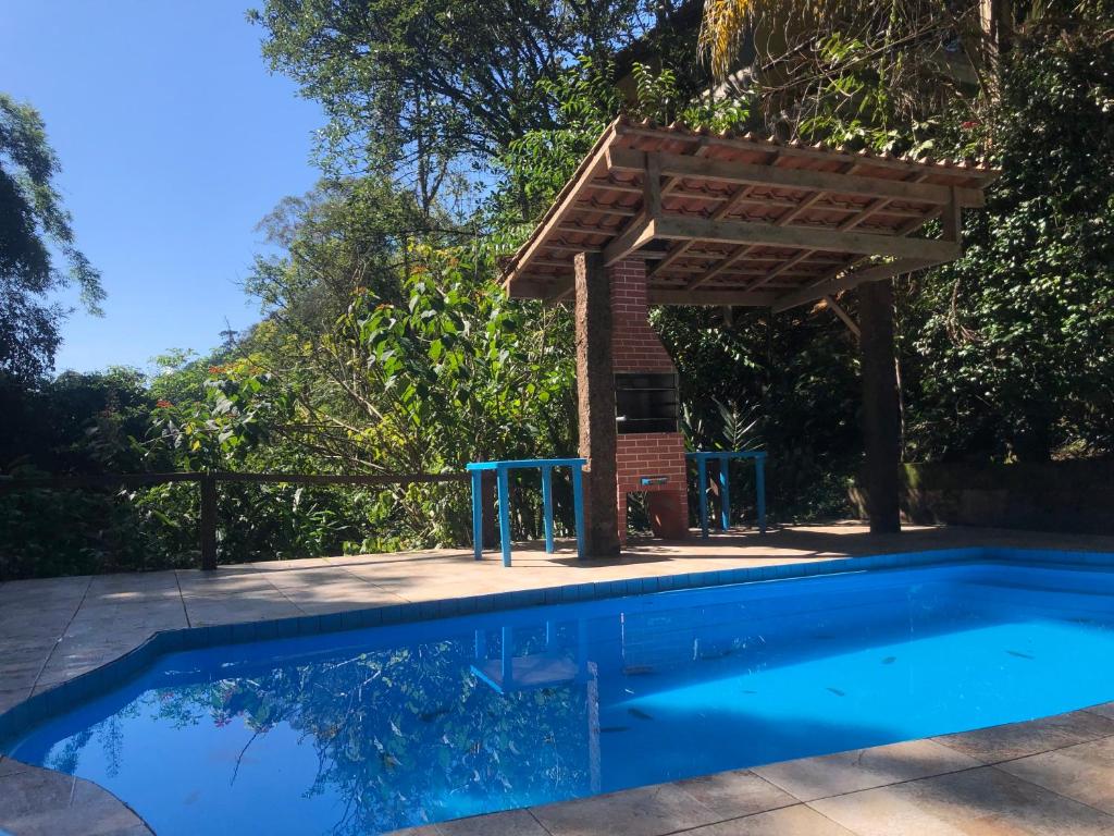 una piscina con una pérgola de madera sobre ella en Casa Bella Ana en Visconde De Maua
