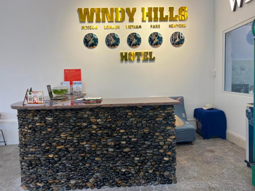 a bar with a pile of wine bottles on a wall at Windy hills hotel in Mui Ne