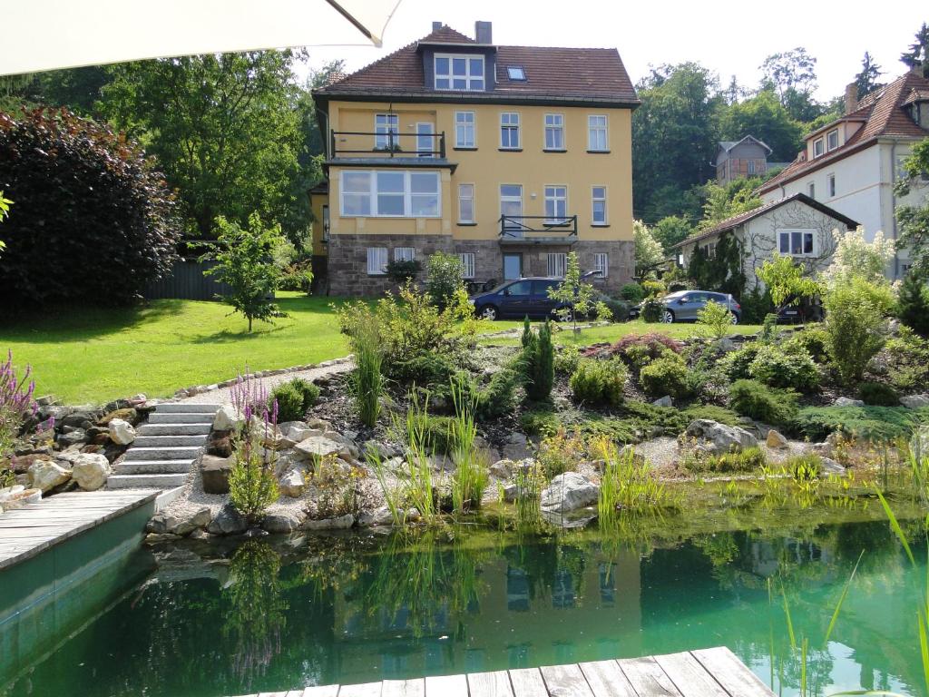 a garden with a pond in front of a house at Pension Villa am Burgberg in Waltershausen