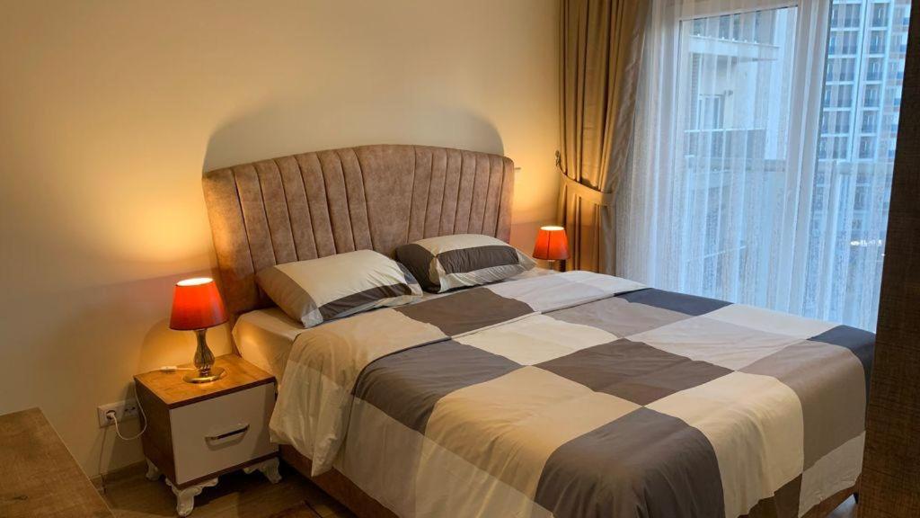 una camera da letto con un grande letto con una grande finestra di شقة سياحية فندقية بمنطقة بشاك شهير بمجمع ميدكولية a Istanbul