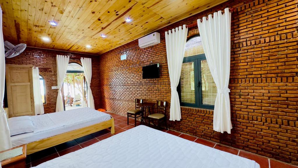 1 Schlafzimmer mit 2 Betten und Ziegelwand in der Unterkunft Da Let House & Coffee 