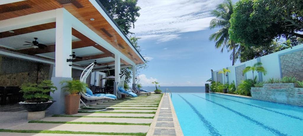 a resort swimming pool with a view of the ocean at Sea Horizon Resort in Zamboanguita