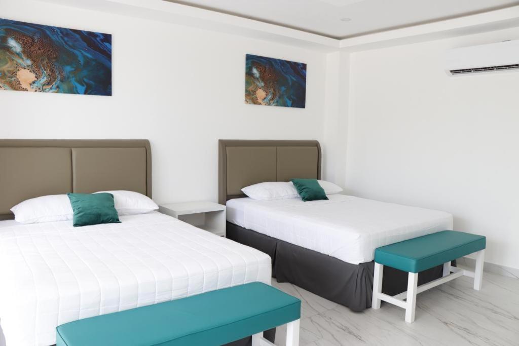 um quarto com duas camas e um banco em The Views Resort em El Zonte