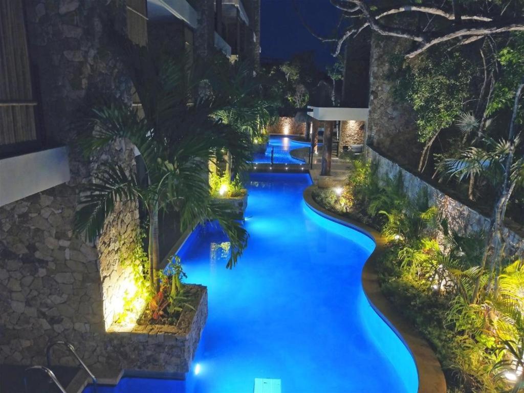 una imagen de una piscina del complejo por la noche en Luxury Aldea Zama 2bed - 2bat Apartment Private Terrace & Swim Up, en Tulum
