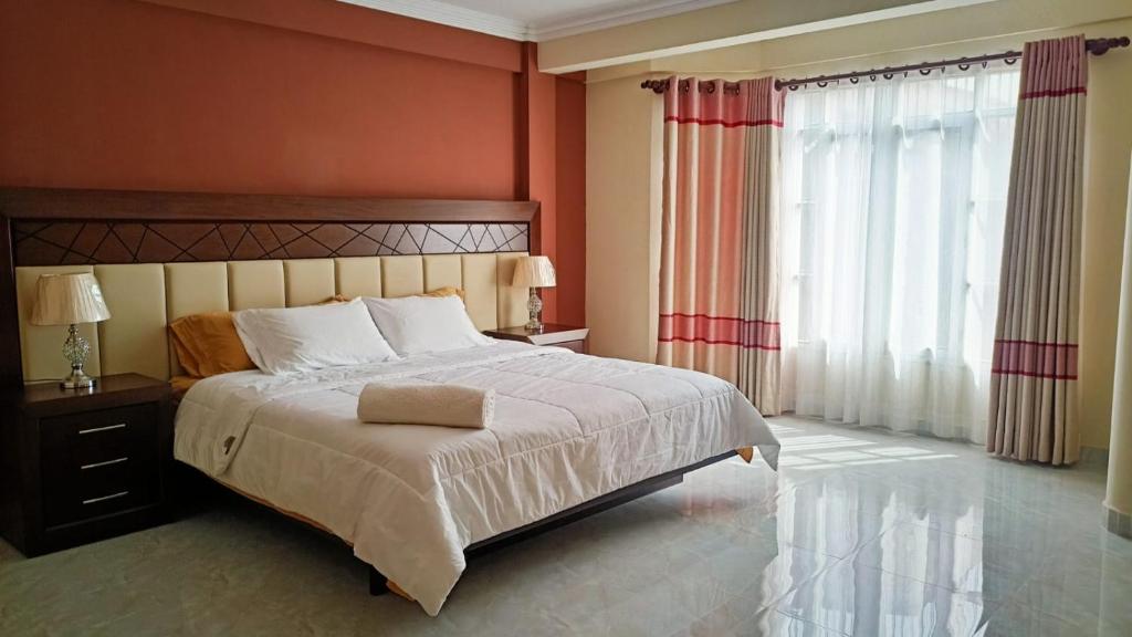 um quarto com uma cama grande e uma janela grande em Apartamento amplio, cómodo y desestresante!!! em Cochabamba