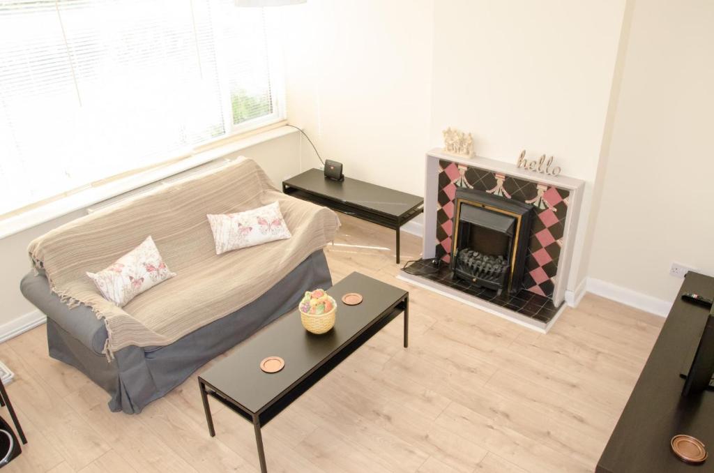a living room with a couch and a fireplace at NEW 2BD Detached House in the Heart of Lincoln in North Hykeham