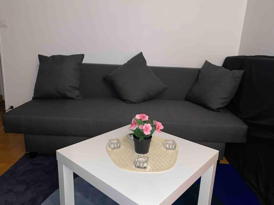 ein Wohnzimmer mit einem Sofa und einem Tisch mit Blumen darauf in der Unterkunft Paris centre in Le Raincy