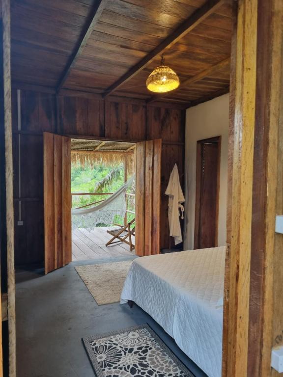 1 dormitorio con 1 cama y puerta corredera de cristal en Ponta Poranga Jungle Lodge, en Manaus