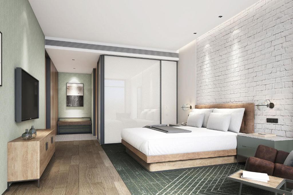 a bedroom with a white bed and a brick wall at Four Points by Sheraton Qiandao Lake in Thousand Island Lake