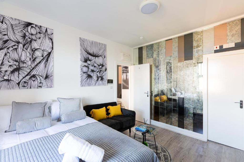 um quarto branco com uma cama e um sofá em Cosy Central Studio Apartment Zone 2 (4) em Londres