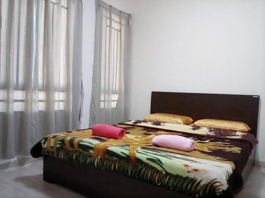 a bed with pillows on it in a bedroom at Cozy Apartment 2 in Telipok Town