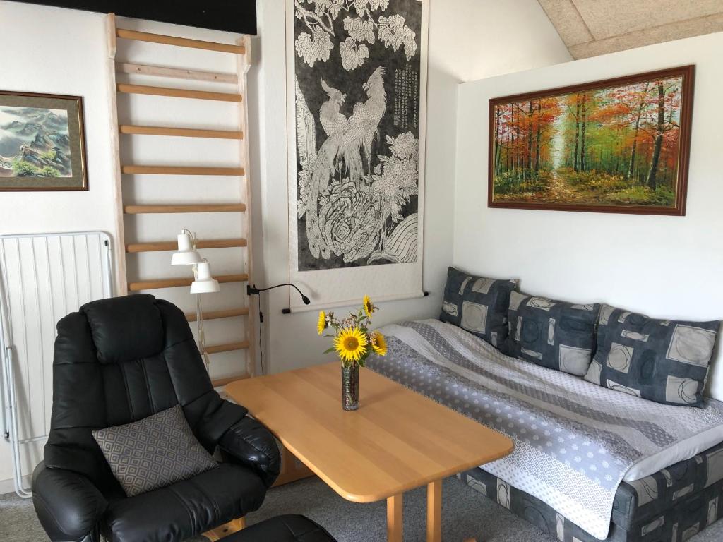 Habitación con sofá, mesa y silla en Medomgaard en Kibæk