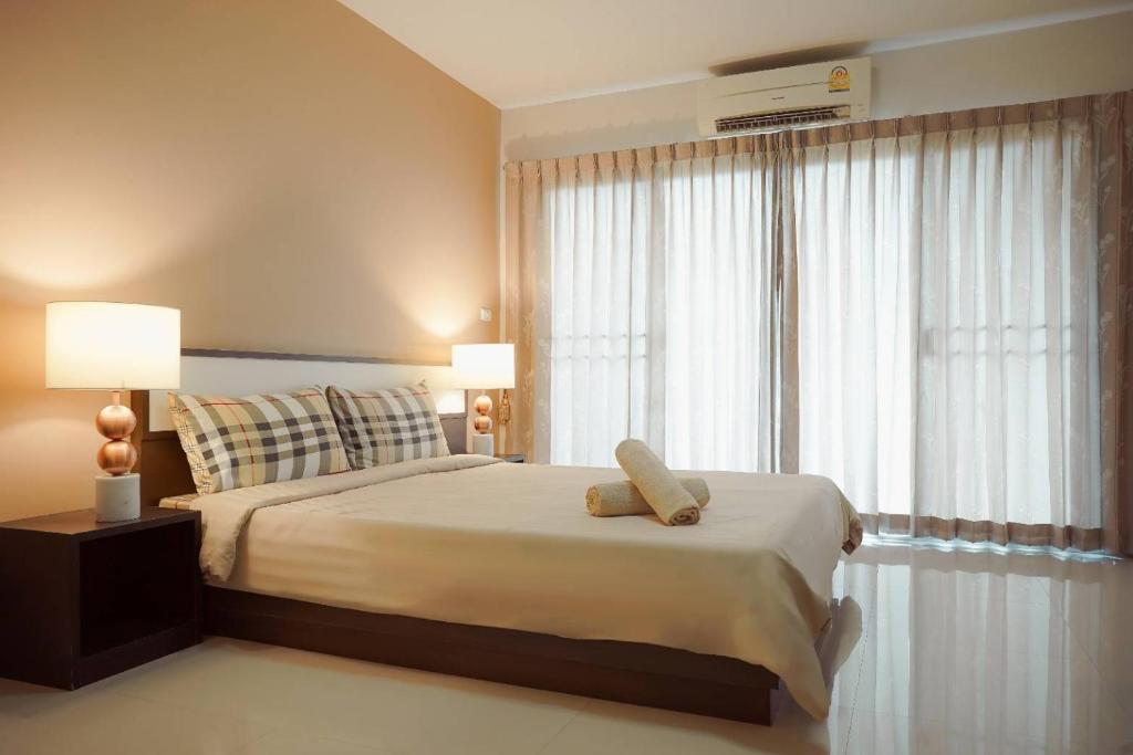 - une chambre avec un lit et une grande fenêtre dans l'établissement Crystal Place, à Nonthaburi