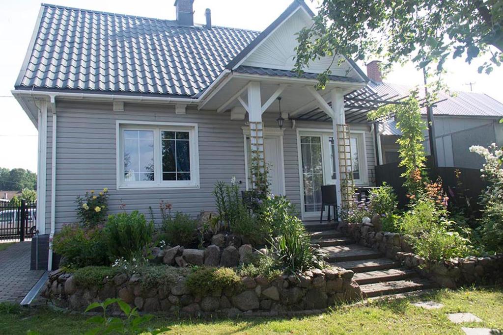 a small house with a rock garden in front of it at Domek w Narewce in Narewka