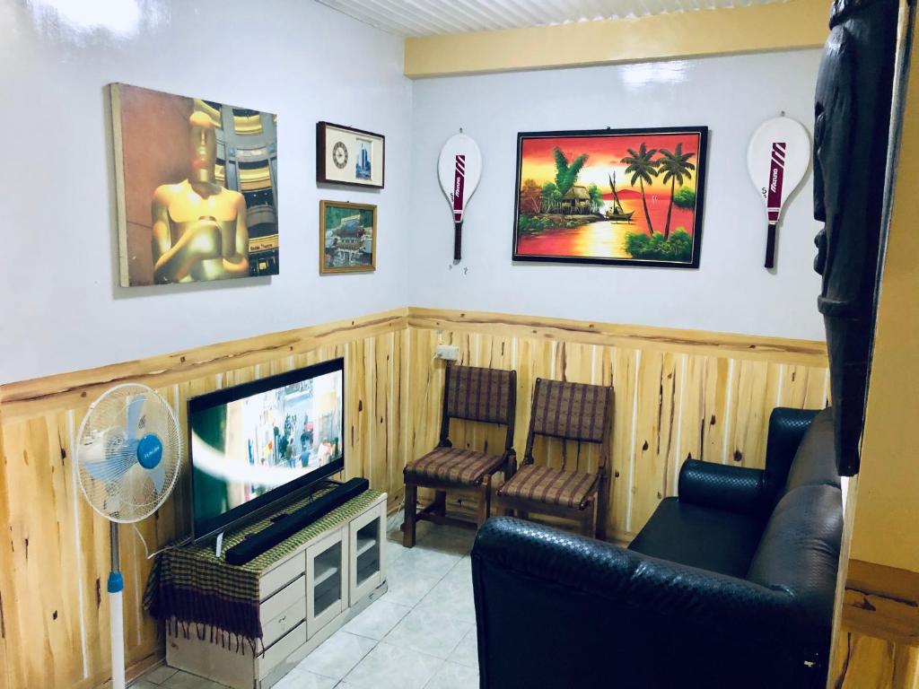 uma sala de estar com televisão e duas cadeiras em Baguio Classic Cozy Home em Baguio