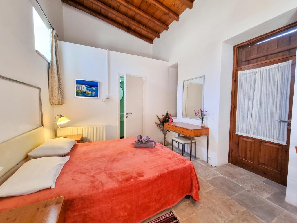 - une chambre avec un grand lit orange et un bureau dans l'établissement Poolside Escape Studio In Skarinou Village with Pool facilities, à Skarinou